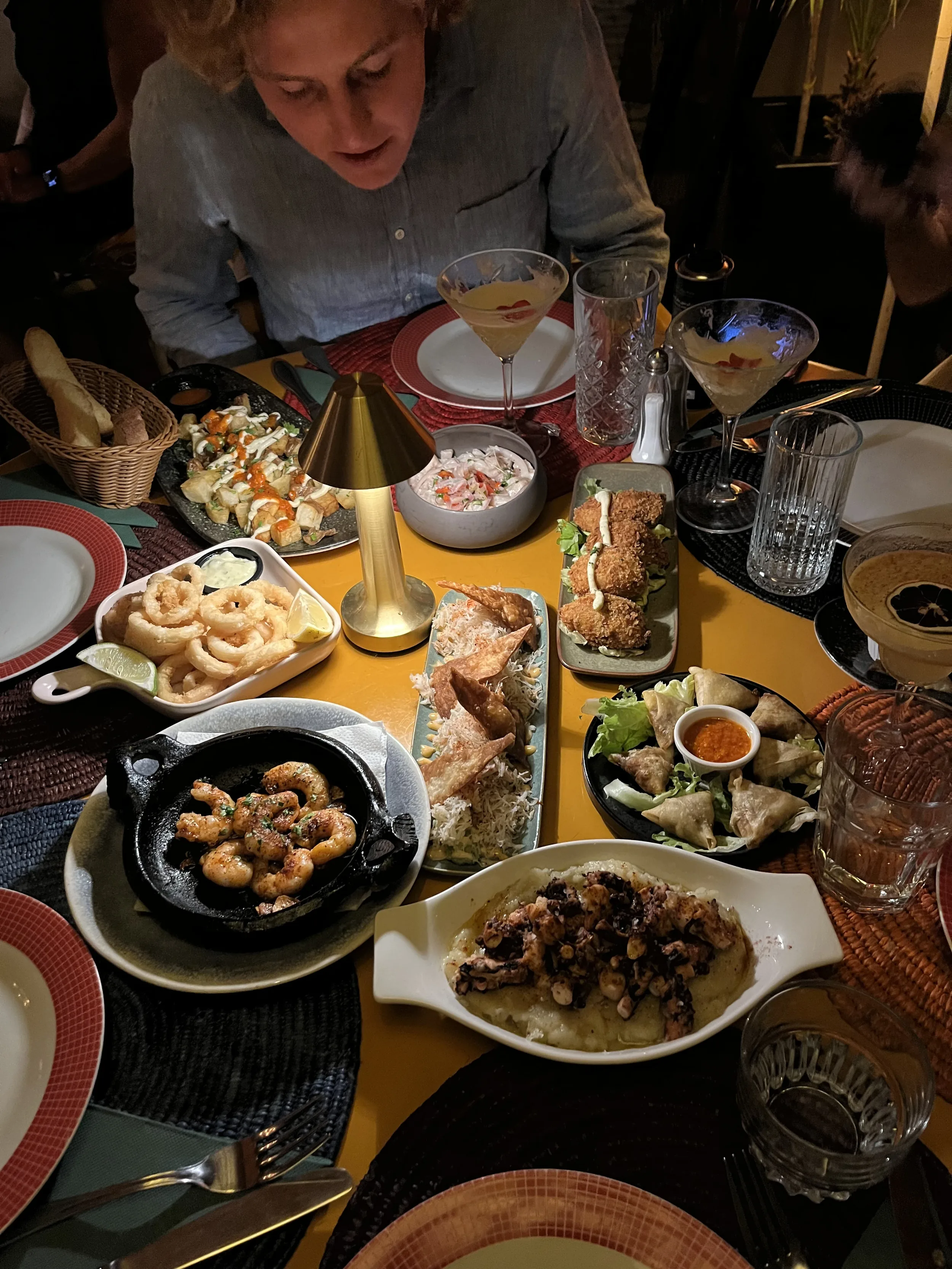 Table de dîner garnie de plats variés et de cocktails lors d'une sortie au restaurant