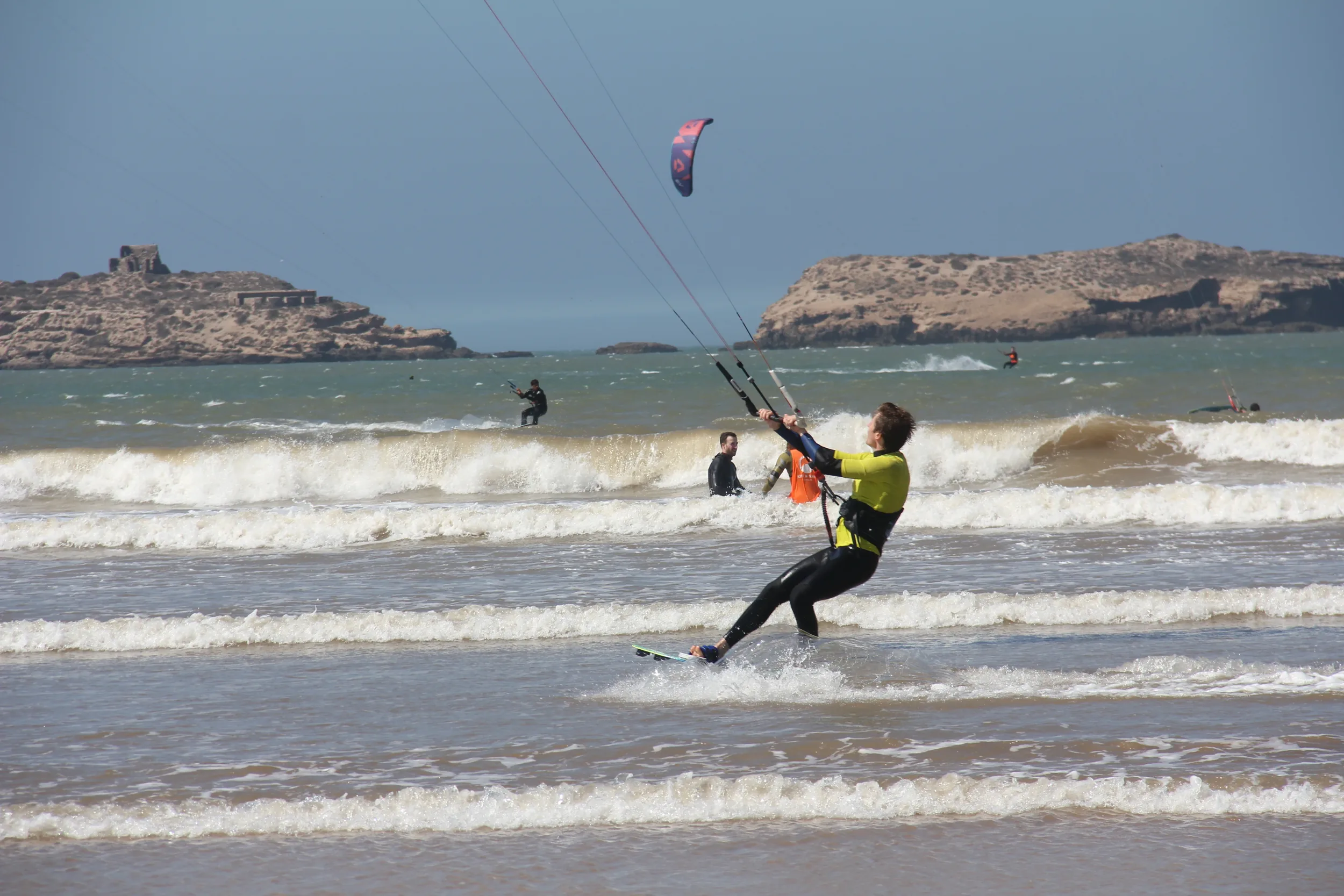 Kitesurfeur glissant sur l'eau au milieu de nombreux riders face aux îles d'Essaouira