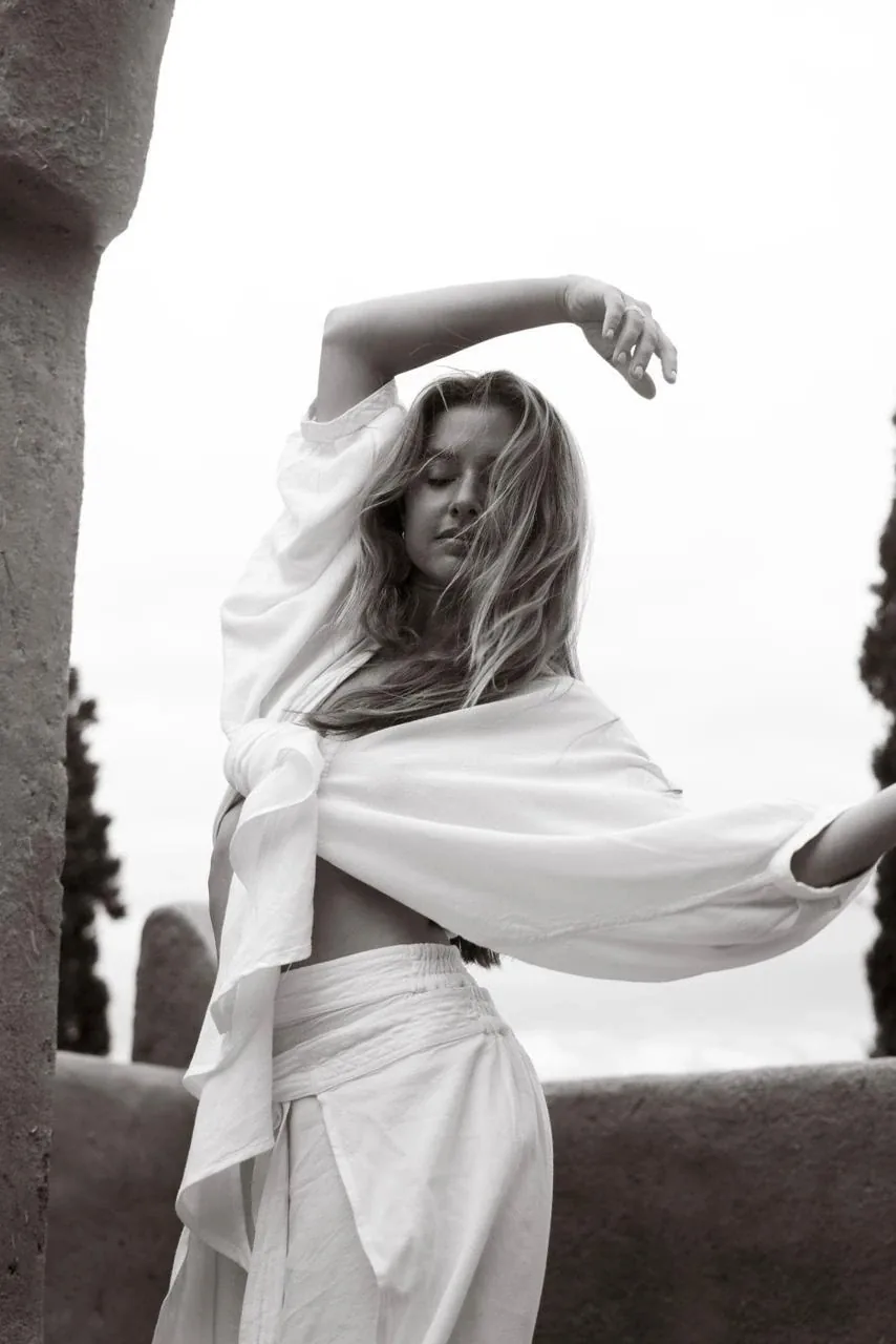 Portrait en noir et blanc d'une femme en mouvement de yoga sur une terrasse, sérénité et bien-être