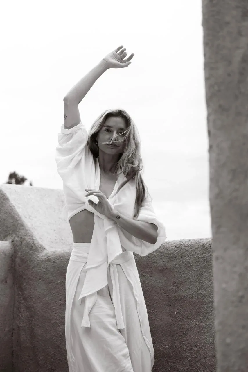 Portrait en noir et blanc d'une femme en mouvement de yoga sur un toit-terrasse en pisé